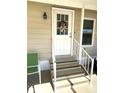 Welcoming front entrance featuring stairs leading up to a white door with decorative wreath at 210 Schooner St, North Port, FL 34287