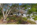 Welcoming single-story home with three-car garage surrounded by mature trees and lush landscaping at 2537 Northway Dr, Venice, FL 34292