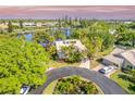 Beautiful aerial view of the home, highlighting the lake view, landscaping and circular driveway at 3 Inlets Blvd # 3, Nokomis, FL 34275