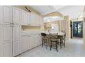 Bright eat-in kitchen featuring breakfast bar, tiled floor, and ample cabinet space at 446 Pendleton Ct, Venice, FL 34292