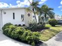 Beautiful single-story home featuring white siding, manicured lawn and decorative palm trees at 473 Sharks Pt, North Port, FL 34287