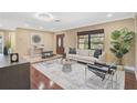 Bright living room featuring hardwood floors, neutral furniture, a modern rug, and lots of sunlight at 641 Bayshore Rd, Nokomis, FL 34275