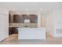 Modern kitchen with island and dark cabinets at 1372 Hartsdale St, North Port, FL 34287