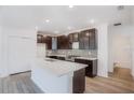 Modern kitchen with island, dark cabinets, and mosaic backsplash at 1372 Hartsdale St, North Port, FL 34287