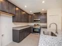 Modern kitchen featuring stainless steel appliances, granite countertops, and ample cabinet space at 5637 Ocarina Rd, North Port, FL 34291