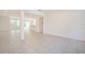 Spacious living area with tile flooring, light walls, and an open floor plan at 5637 Ocarina Rd, North Port, FL 34291