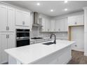 Modern kitchen featuring white cabinets, stainless steel appliances, and a large island at 1005 Signet, Apollo Beach, FL 33572