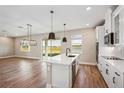 Open concept kitchen with island, stainless steel appliances, and view to backyard at 101 Runaway Field Ave, Nokomis, FL 34275