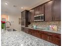Granite countertop kitchen with stainless steel appliances and mosaic backsplash at 25134 Doredo Dr, Punta Gorda, FL 33955