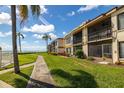 Exterior view of condo building with well-maintained landscaping and pathway to the beach at 6268 Palma Del Mar S Blvd # 204, St Petersburg, FL 33715