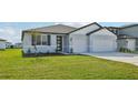 Two-story house with gray siding, two-car garage, and a grassy yard at 14023 Ginnie Springs Way, Parrish, FL 34219