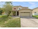 Two-story house with tan exterior, red accents, and a two-car garage at 10617 Bamboo Rod Cir, Riverview, FL 33569