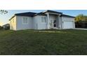 Contemporary single-Gathering home boasts neutral stucco, double-door entry, and an attached two-car garage at 10071 Kingsville Dr, Port Charlotte, FL 33981