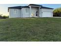 Contemporary single-Gathering home boasts neutral stucco, double-door entry, and an attached two-car garage at 10071 Kingsville Dr, Port Charlotte, FL 33981