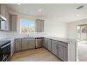 Modern kitchen with gray cabinets, granite countertops, and stainless steel appliances at 37736 Yukon Dr, Zephyrhills, FL 33540