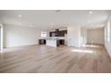 Open concept kitchen with island, dark cabinetry, and hardwood floors at 37545 Mackenzie Dr, Zephyrhills, FL 33540