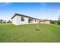 View of the back of the house and the spacious grassy backyard at 16229 Cape Horn Blvd, Punta Gorda, FL 33955
