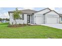 Newly built home with light-gray exterior, two-car garage, and a neat lawn at 14006 Ginnie Springs Way, Parrish, FL 34219