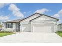 Two-story home with light-gray exterior, two-car garage and neatly landscaped yard at 14006 Ginnie Springs Way, Parrish, FL 34219