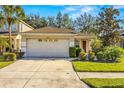 Tan house with two car garage and neatly landscaped yard at 7851 Tuscany Woods Dr, Tampa, FL 33647