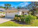 One-story house with a two-car garage, and lush landscaping at 7851 Tuscany Woods Dr, Tampa, FL 33647