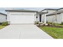 Front view of a house with a white garage door and landscaping at 14052 Crutchfield Ct, Parrish, FL 34219