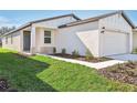 One-story home with white exterior, two-car garage, and landscaping at 14053 Crutchfield Ct, Parrish, FL 34219