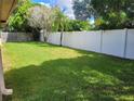 Large grassy backyard with a white vinyl fence at 2587 Blackwood Cir, Clearwater, FL 33763