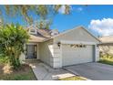 One-story house featuring a gray front door and a white garage door at 8610 Hawbuck St, Trinity, FL 34655