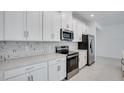 Modern kitchen with white cabinets, stainless steel appliances, and quartz countertops at 1564 Laurel Brook Ln, Port Charlotte, FL 33953