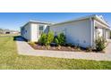 Home's side elevation showcasing landscaping and walkway at 16093 Ivy Ridge Ct, Port Charlotte, FL 33953