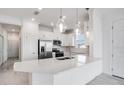 Modern kitchen with white cabinets, stainless steel appliances, and an island at 16093 Ivy Ridge Ct, Port Charlotte, FL 33953