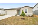 New construction home with a two-car garage and a small front yard at 31650 Malbec Dr, Brooksville, FL 34602