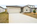 Tan house with a two-car garage and a well-manicured lawn at 31650 Malbec Dr, Brooksville, FL 34602