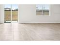 Bright and airy living area with tile floors and sliding glass doors at 31650 Malbec Dr, Brooksville, FL 34602