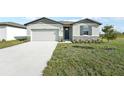Curb appeal! A charming one-story house with gray siding, stone accents, and a two-car garage at 31703 Wild Grape Ln, Brooksville, FL 34602