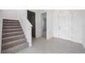 Interior view of a foyer with carpeted stairs and tile floor at 37598 Mackenzie Dr, Zephyrhills, FL 33540