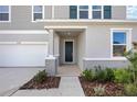 House entrance with gray siding, dark door, and covered porch at 37598 Mackenzie Dr, Zephyrhills, FL 33540