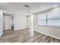 Bright living room featuring wood-look floors and neutral walls at 7311 Buchanan Dr, Port Richey, FL 34668