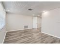 Bright living room featuring light gray walls and wood-look flooring at 7311 Buchanan Dr, Port Richey, FL 34668