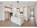 Modern kitchen featuring white cabinets, quartz countertops, and an island at 117 Runaway Field Ave, Nokomis, FL 34275