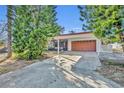 House exterior showcasing carport and orange garage door at 990 Sunrise Dr, Tarpon Springs, FL 34689