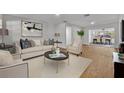 Living room features light beige couch, wood floors, and view to dining area at 990 Sunrise Dr, Tarpon Springs, FL 34689