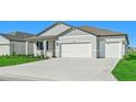 Two-car garage, gray siding, and landscaping at 13855 Richland Gulf Cir, Parrish, FL 34219