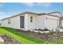 White one-story house with gray door and landscaping at 14037 Crutchfield Ct, Parrish, FL 34219