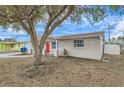Tan house with red door and large tree in front at 3531 Oxford Dr, Holiday, FL 34691
