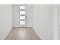 Bright entryway with light wood-look flooring and a modern door at 13868 Richland Gulf Cir, Parrish, FL 34219