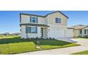 Two-story house with beige siding, blue shutters, and a three-car garage at 13868 Richland Gulf Cir, Parrish, FL 34219