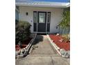 Beautiful entryway with a decorative glass door and sidelights, enhanced by stone-lined flower beds at 1908 40Th W St, Bradenton, FL 34205