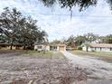 Front view of a single story home with a driveway and mature trees at 4935 Mockingbird Dr, Dade City, FL 33523
